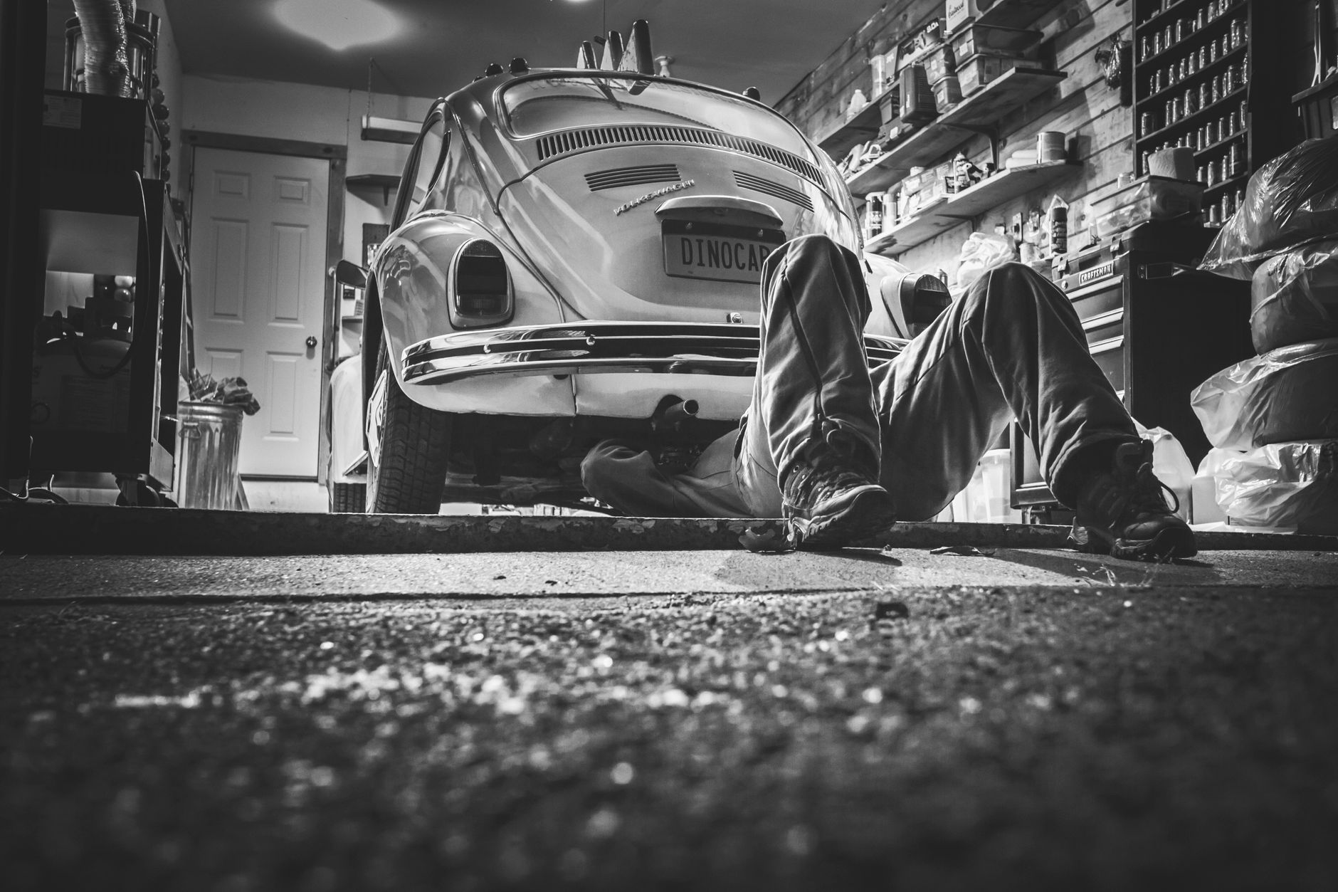 A mechanic working underneath a classic Beetle