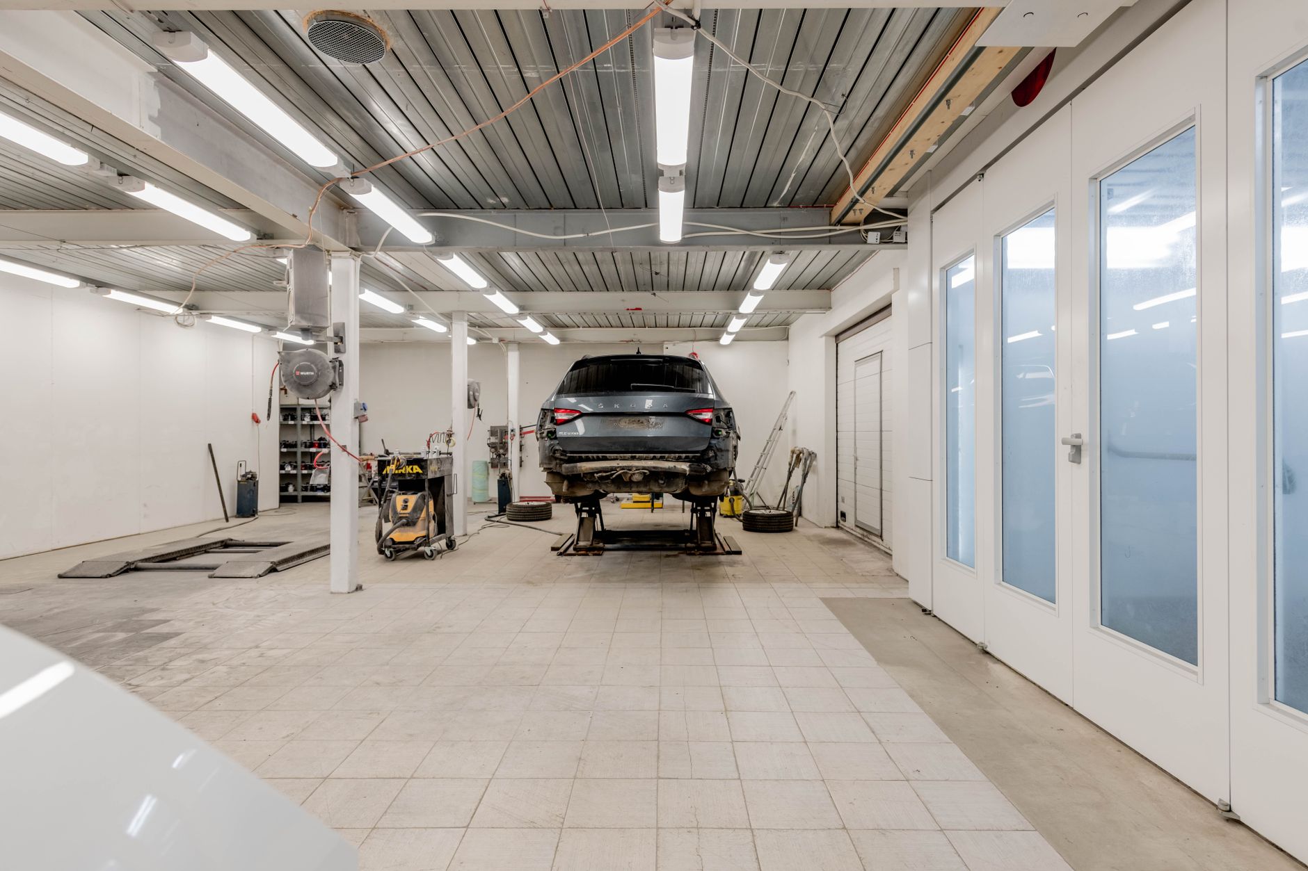 A car raised on a lift in a bright, clean workshop